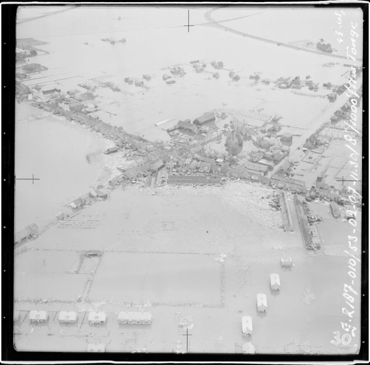 Luchtfoto van Nieuwe-Tonge met een overzicht van het door de Watersnoodramp getroffen gebied.  In het midden de Hervormde Kerk aan de Kerkring.