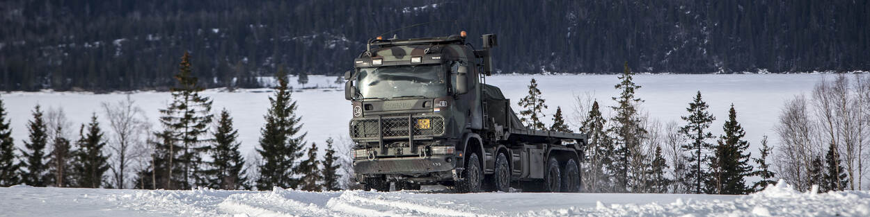 Een Scania-wissellaadsysteem rijdt door de sneeuw tijdens de internationale oefening Cold Response in Noorwegen (maart 2016).