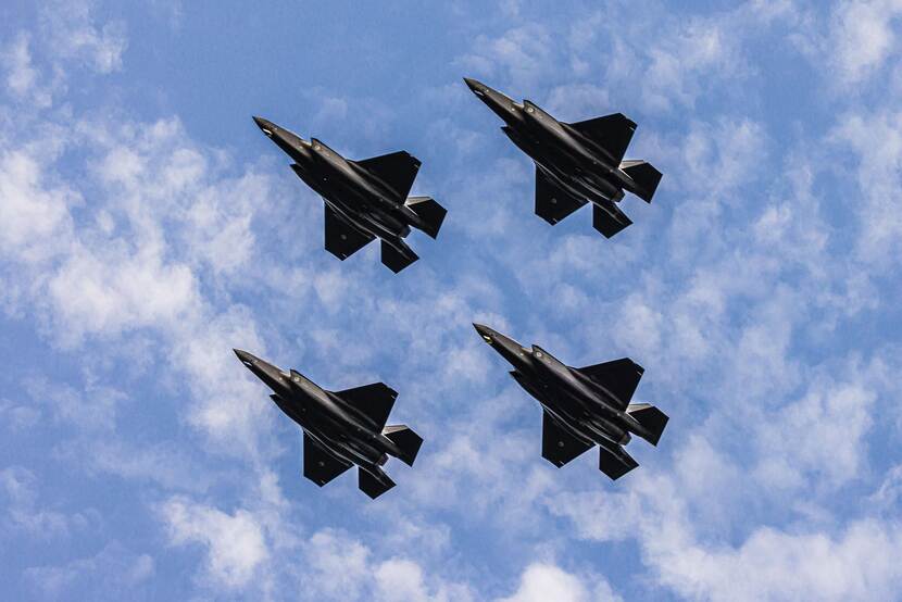 Archieffoto van 4 F-35's van onderen gezien, tegen een blauwe lucht met wolkjes.
