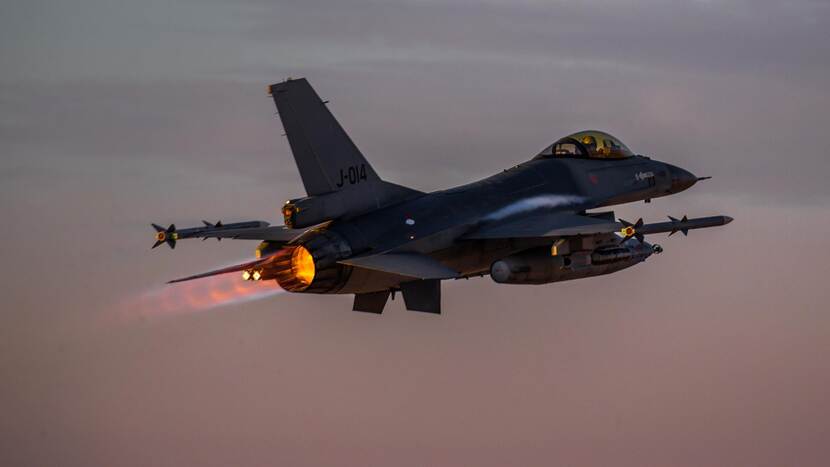 Een F-16 in een donker wordende lucht.