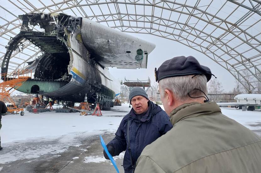 Generaal Eichelsheim spreekt met een Oekraïense man, op de achtergrond een vliegtuigwrak.