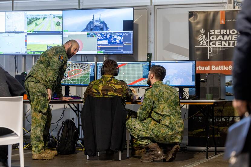 Militairen achter grote computerschermen.