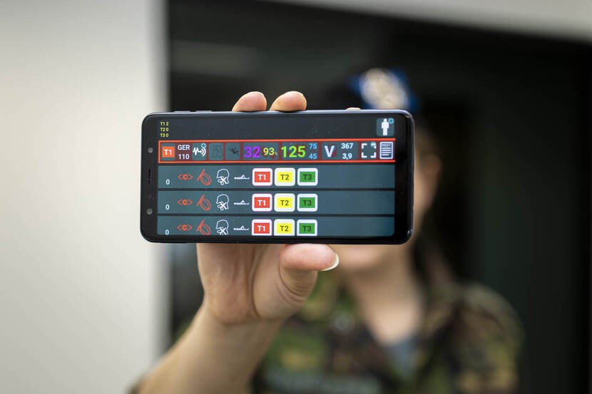 Militair toont telefoon met app.