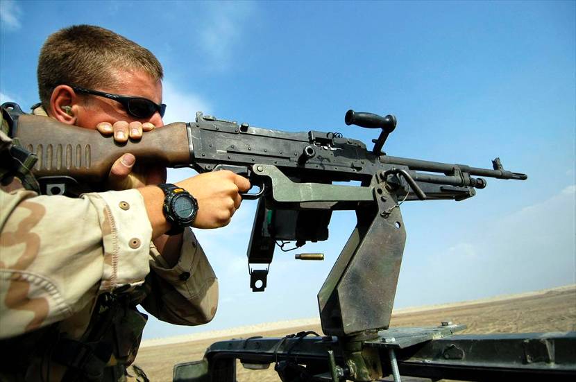 Een militair oefent met een MAG mitrailleur, gemonteerd op een jeep, op de schietbaan bij As Samawah, Irak (2004).