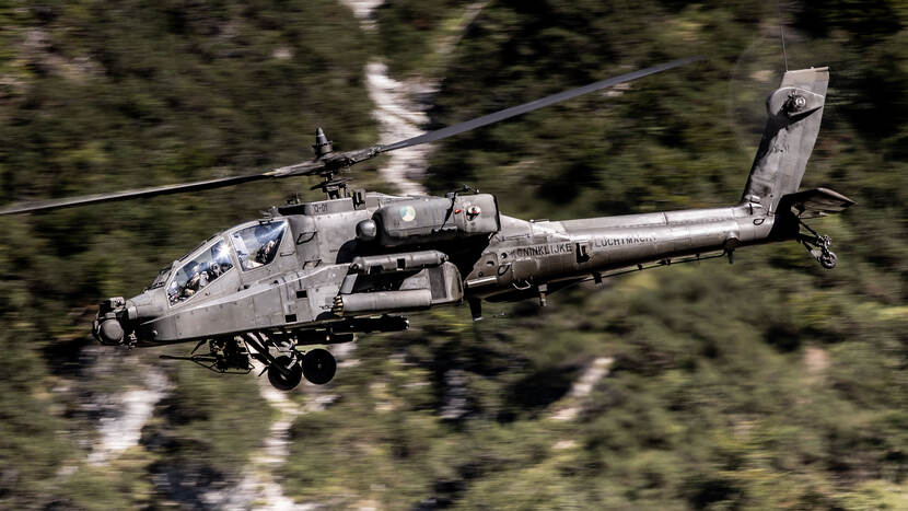 Zijaanzicht van een Apache Delta-gevechtshelikopter in de lucht.