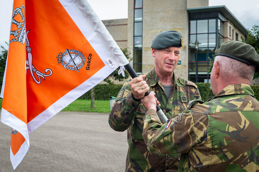 Landmachtcommandant Wijnen draagt symbolisch de vlag over.