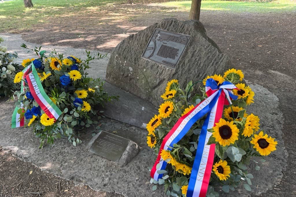 Bloemstukken bij een gedenksteen.