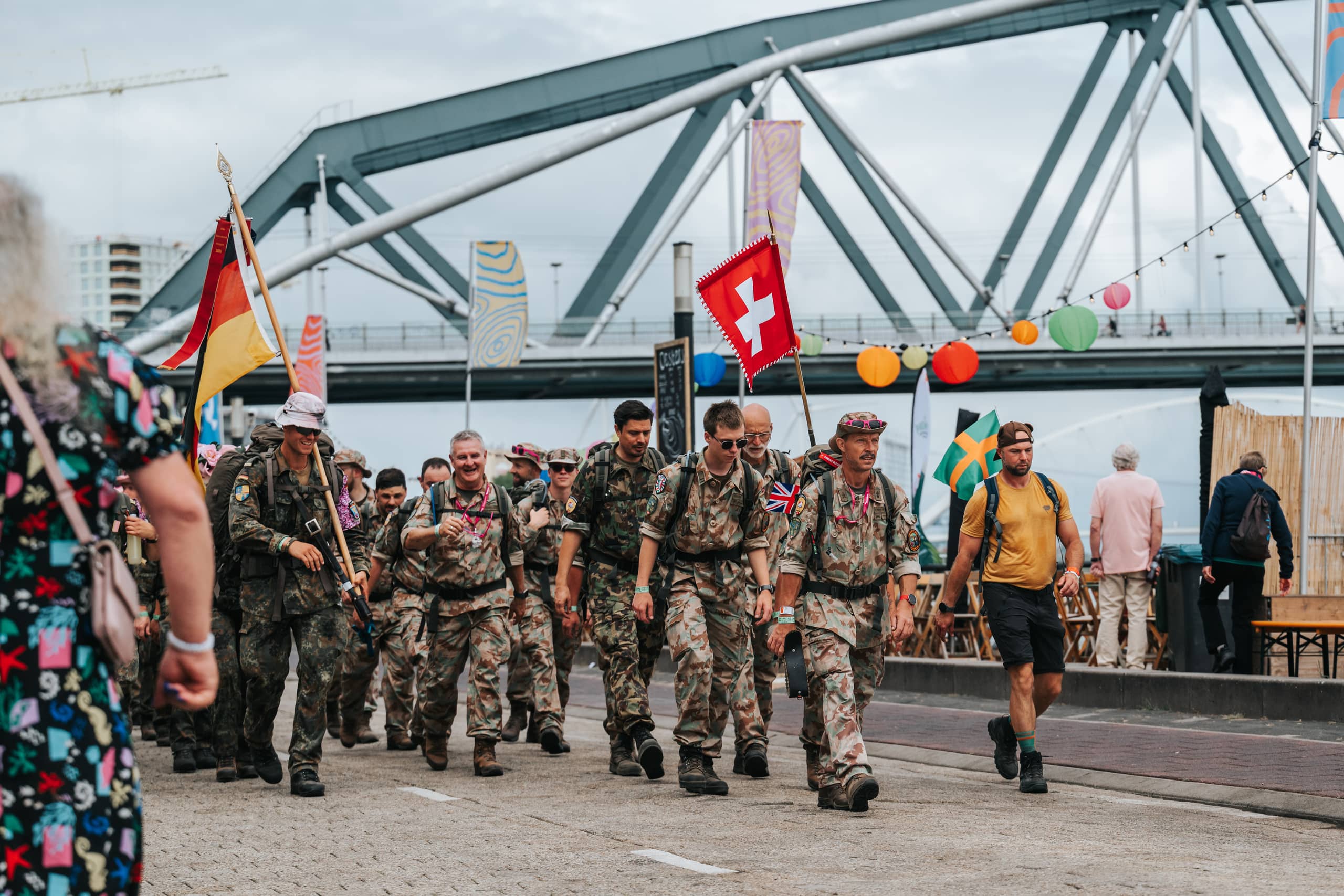 Militairen lopen met vlaggen uit verschillende landen.