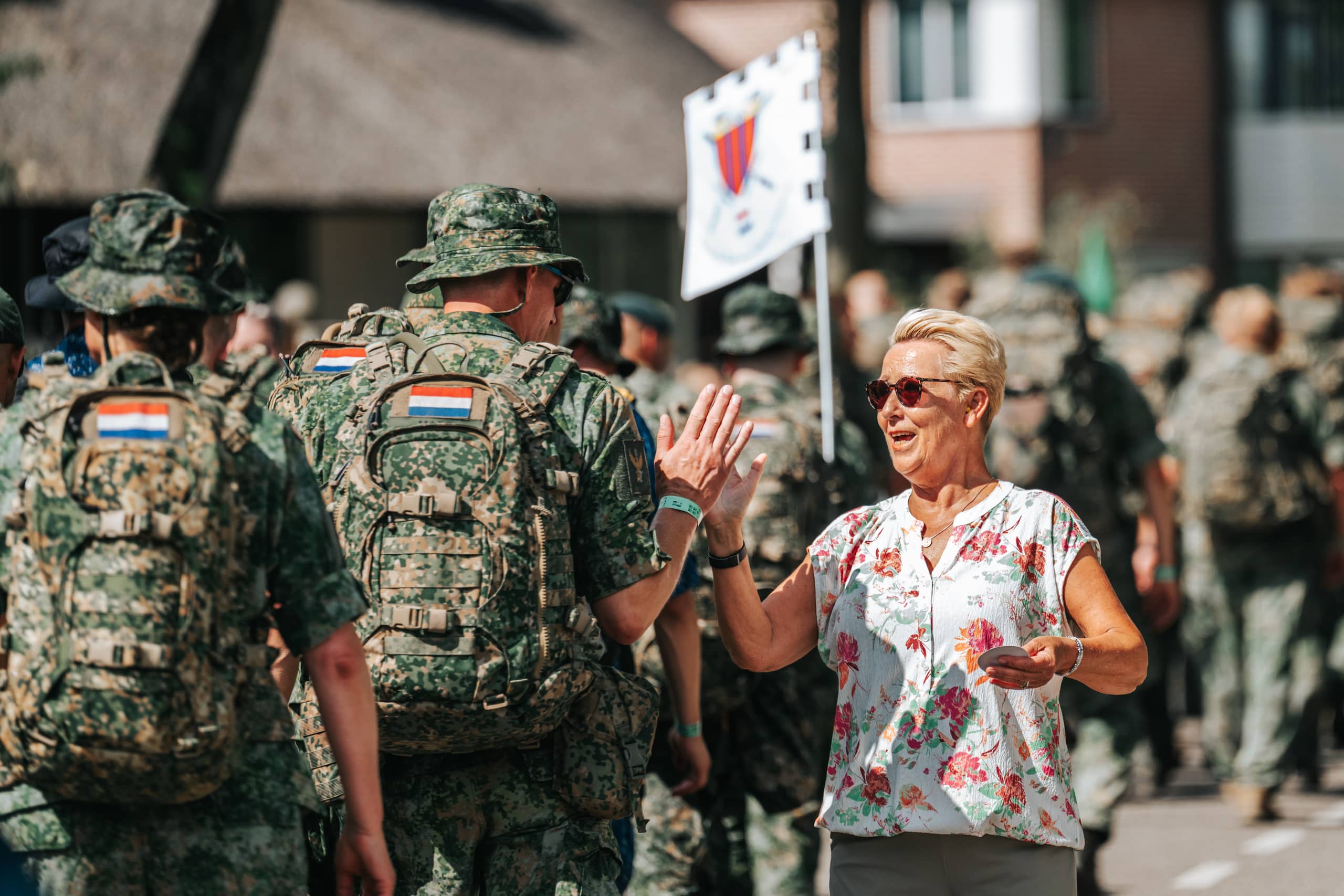 Een militair groet een toeschouwer.