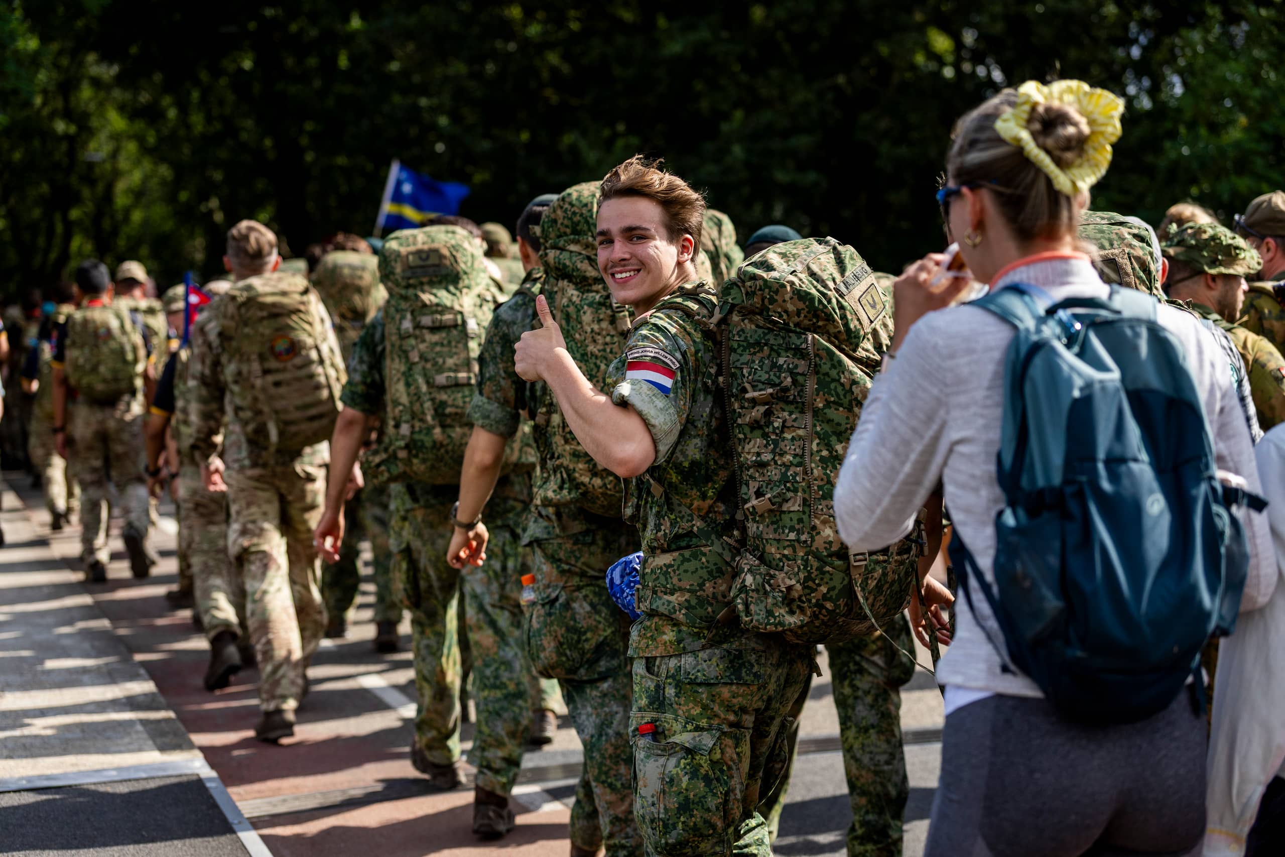 Een militair kijkt groetend achterom tijdens de wandeltocht.