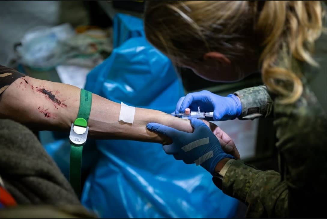 Een militair krijgt een injectie in de onderarm