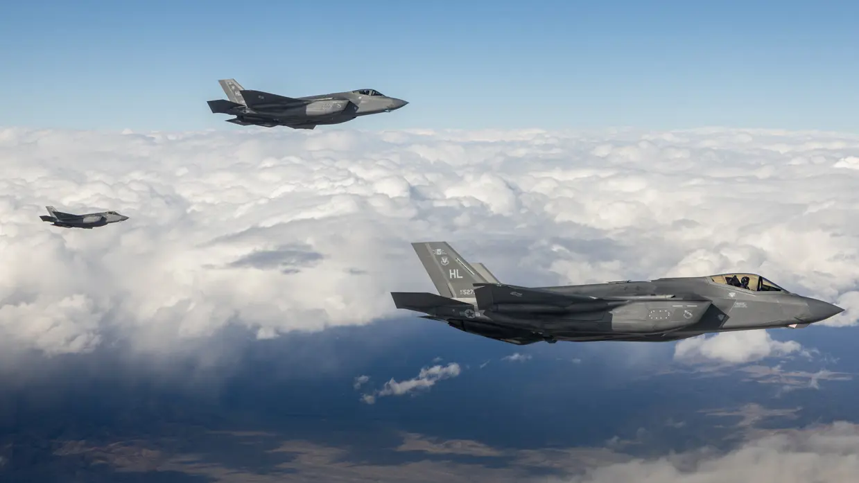 Drie F-35’s vliegend boven een wolkendek.