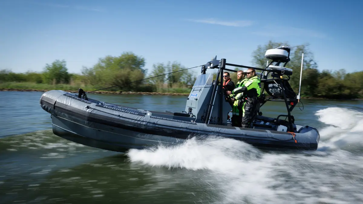3 man staan op een rubberenboot van de marechaussee.