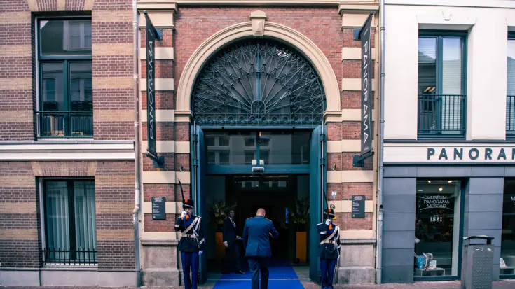 Twee militairen vormen een erewacht bij een entree.