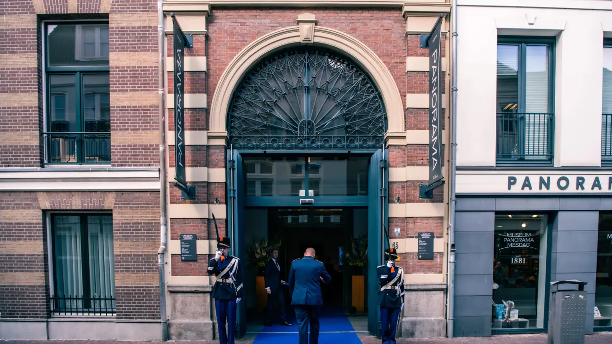 Twee militairen vormen een erewacht bij een entree.