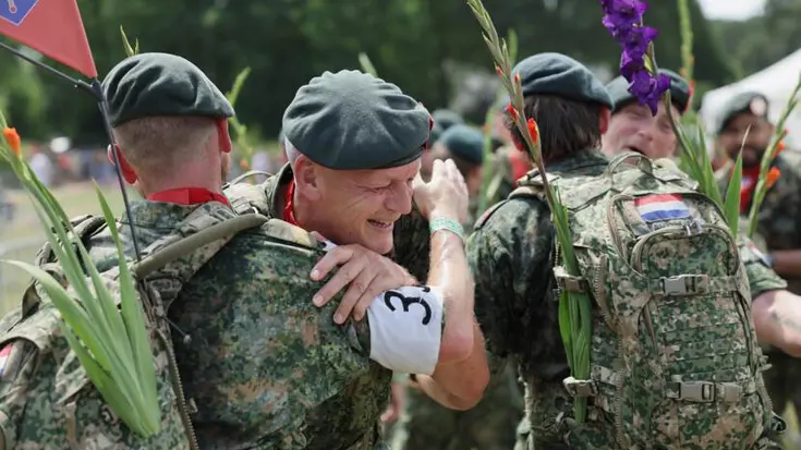 Militairen feliciteren elkaar na uitlopen Nijmeegse Vierdaagse. 