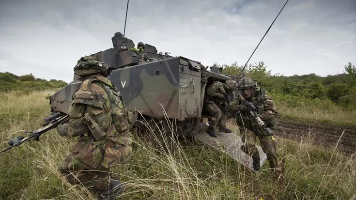 Militairen stijgen uit een pantservoertuig.