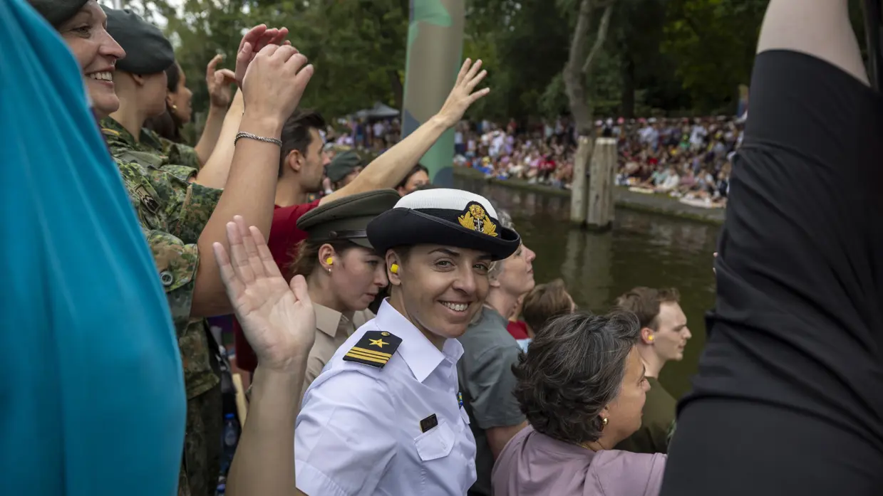 Militairen en burgermedewerkers op een boot bij de Canal Parade.