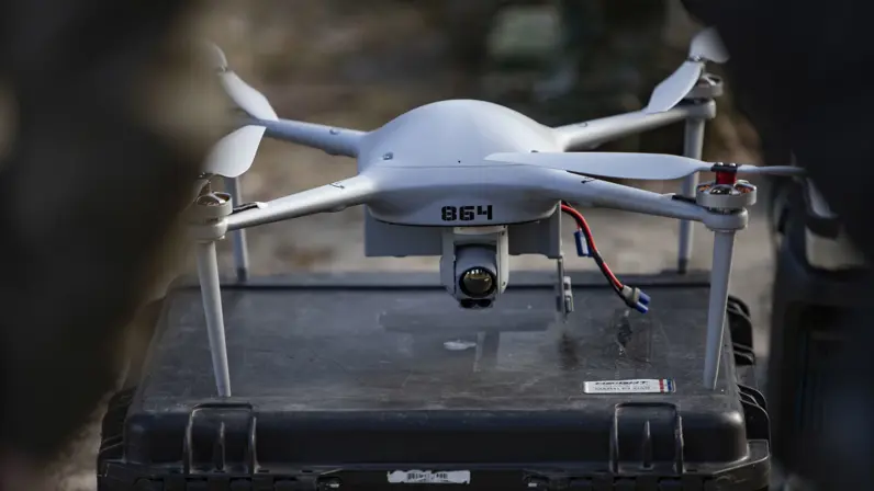 Drone met camera geplaatst op een transportkoffer, klaar voor inzet in het veld. 