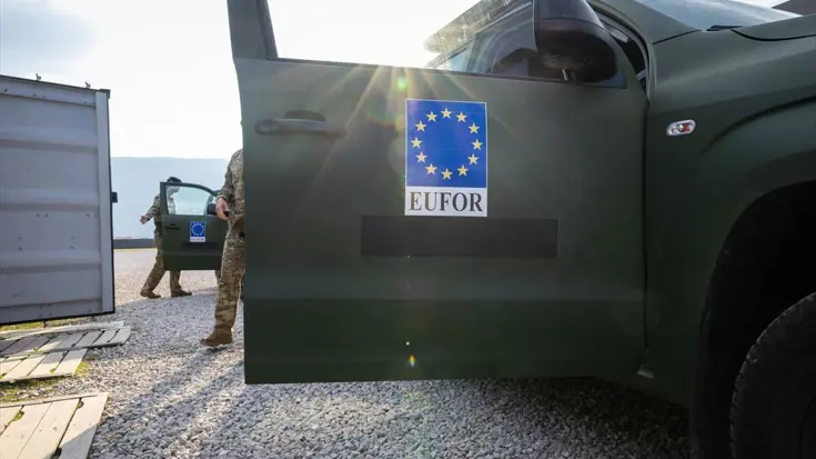 Een openstaand portier van een militair voertuig met daarop het embleem van Eufor