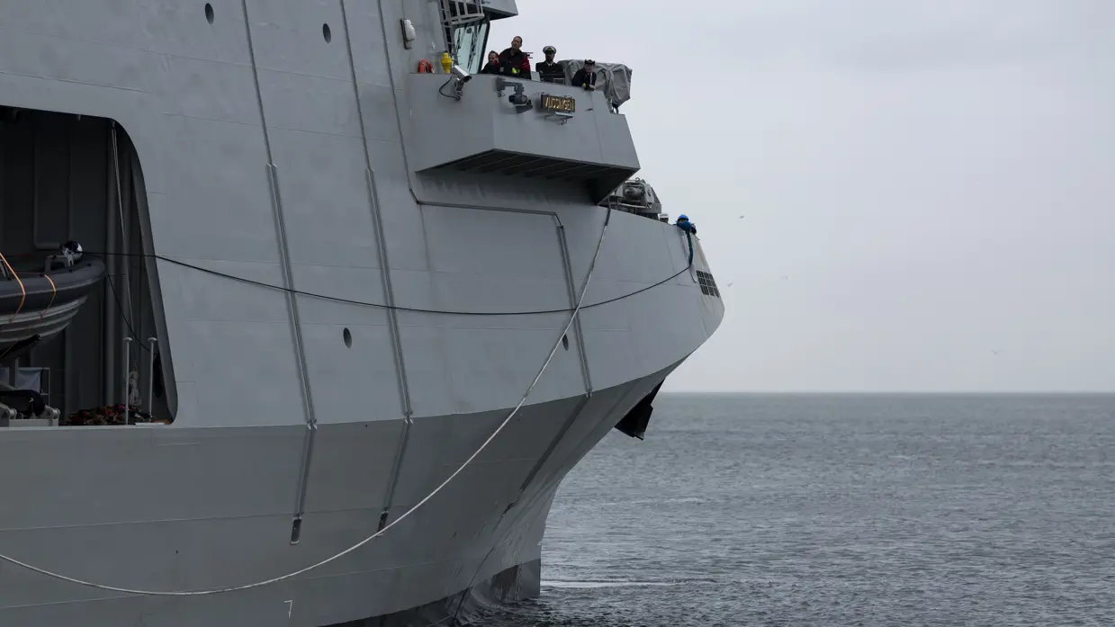Het voorste gedeelte van het varende marineschip. Op de afbeelding is de brug te zien, waarop enkele militairen van de marine staan. 