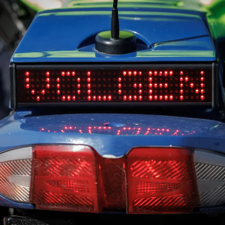 Een sein ‘volgen’ achterop een motor van de Koninklijke Marechaussee.