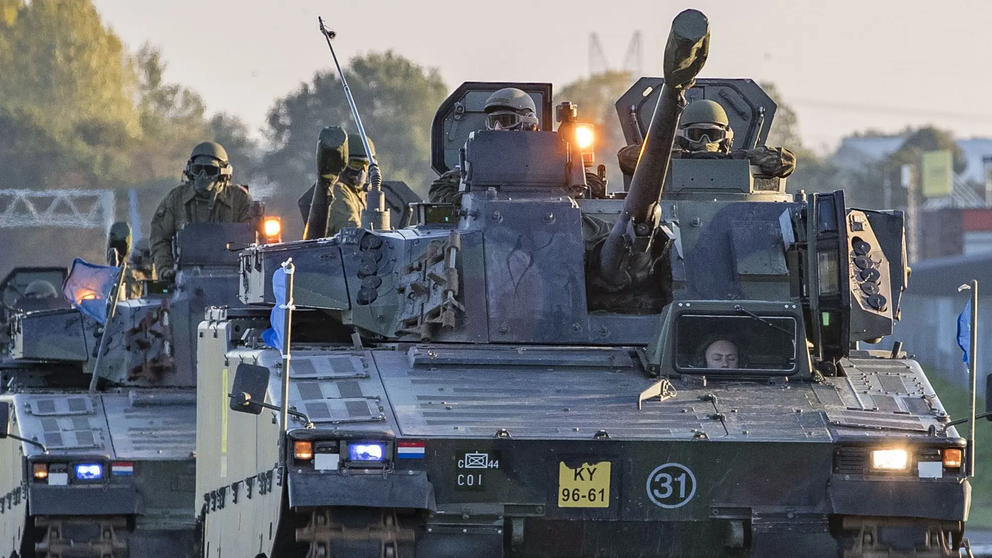 Militaire colonne rijdt over snelweg.