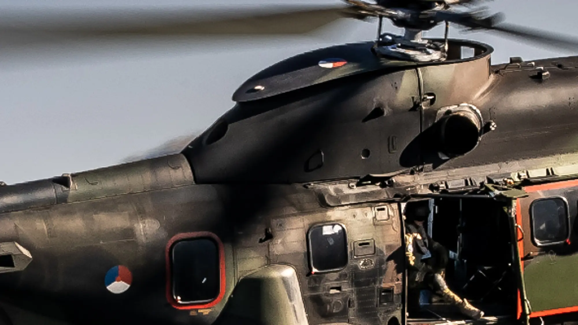 Cougar-transporthelikopter vliegt door de lucht met bergen op de achtergrond.