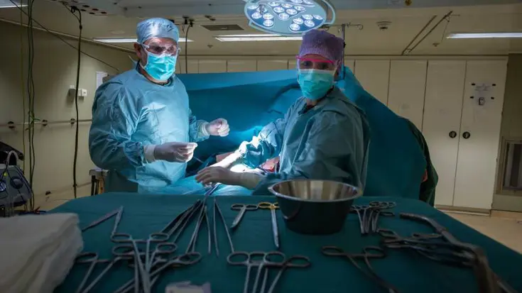 2 mensen van medisch team in het groen in een operatiekamer aan boord van een marineschip.een