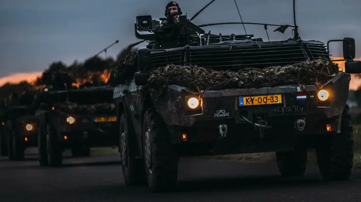 Fennek-verkenningsvoertuigen rijden in schemering.