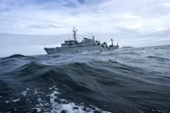 De Zr.Ms. Willemstad, schuin liggend op volle zee met hoge golven