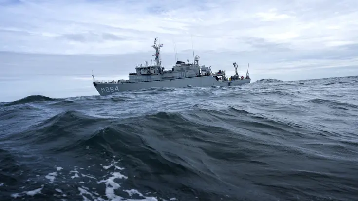 De Zr.Ms. Willemstad, schuin liggend op volle zee met hoge golven