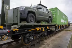 Containerwagon inclusief jeep staan klaar op spoor.