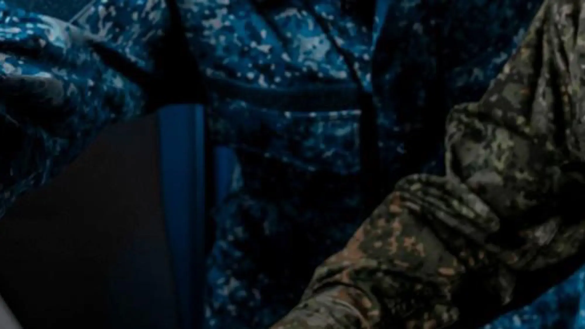 Twee militairen zitten achter een laptop.