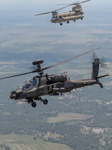 Een Apache en Chinook vliegend over Texaans landschap.