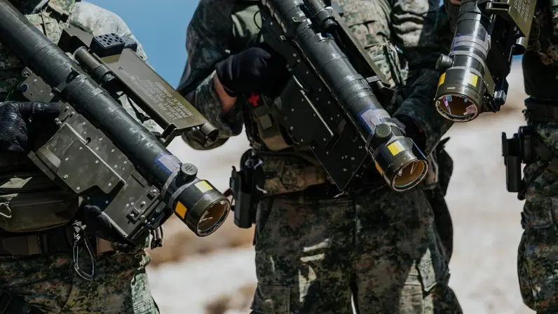 Close-up van 3 mariniers met een Stinger op hun schouders, de wapens zijn naar beneden gericht.