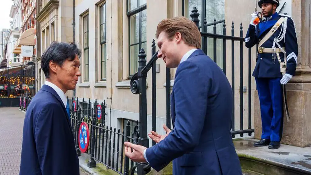 De Japanse ambassadeur Rokuichiro Michii en minister Brekelmans staan bij de voordeur van het ministerie van Defensie in Den Haag.