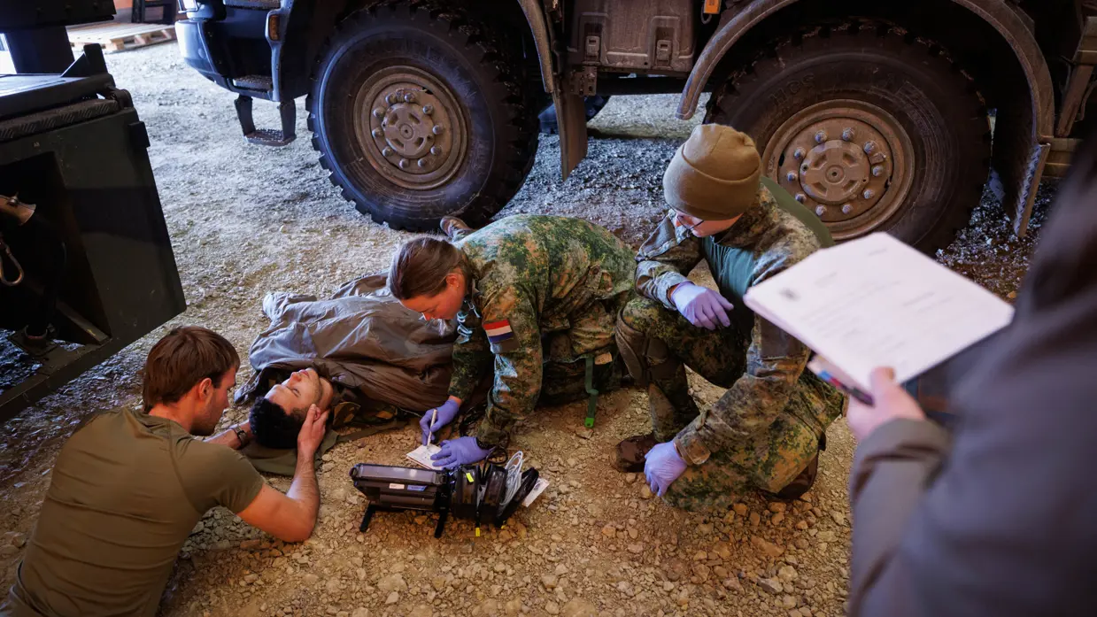 Militairen verzorgen een gewonde collega.