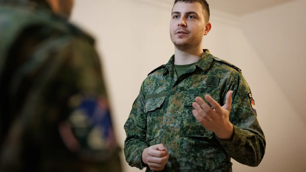 Portretfoto van Dani in gesprek met een collega-militair.