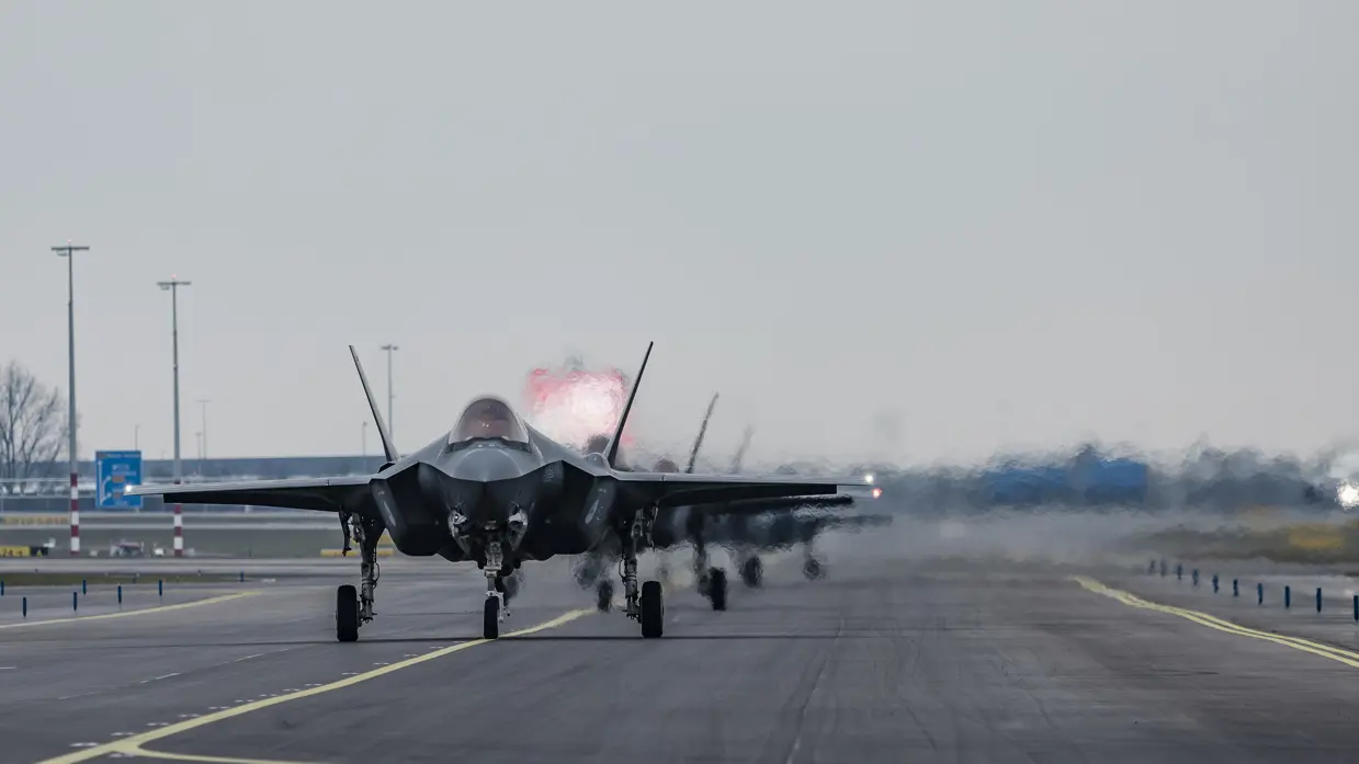 Links F-35’s opgelijnd op de startbaan van Schiphol, rechts: Een tank- en transportvliegtuig A330 MRTT landt op luchthaven Schiphol. De wielen raken net de grond wanneer de foto wordt gemaakt, waardoor er een klein rookwolkje ontstaat.  
