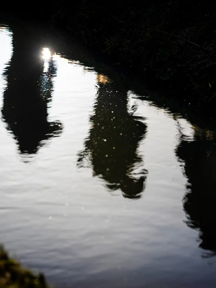 Weerspiegeling van militairen op het water.