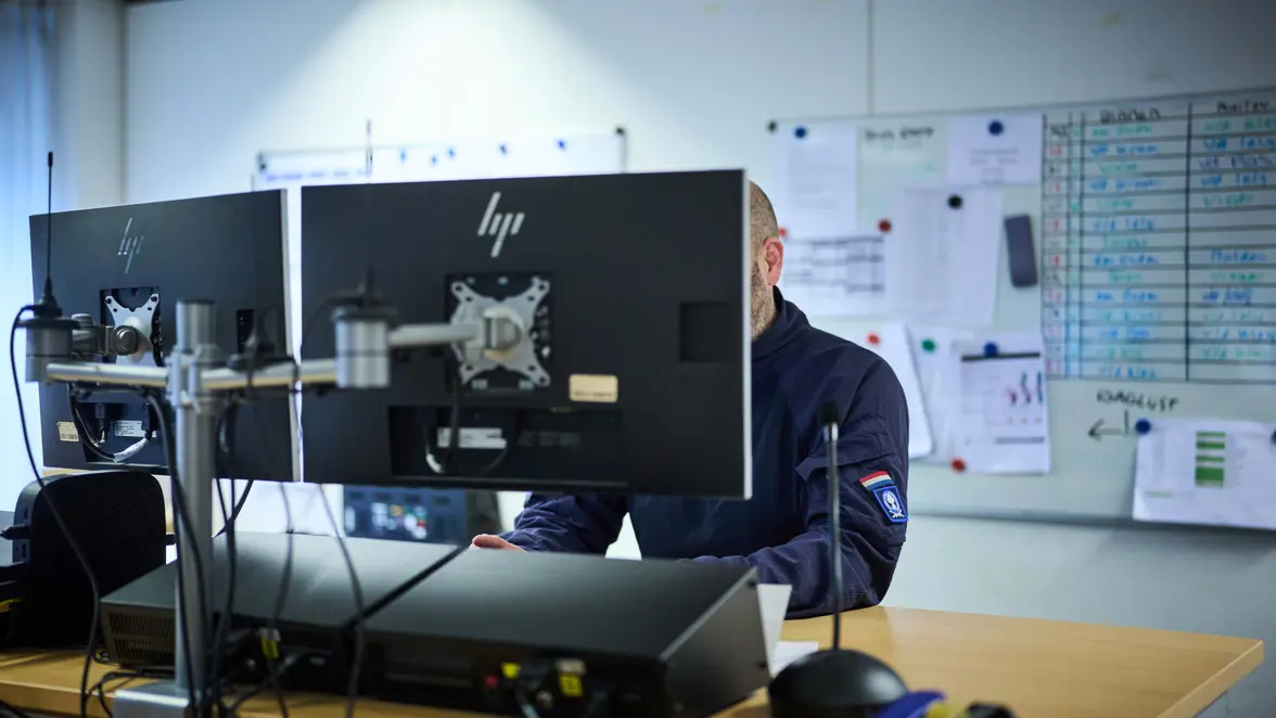De teamleider van de afdeling Planning bekijkt op computerschermen de roosters van het personeel.