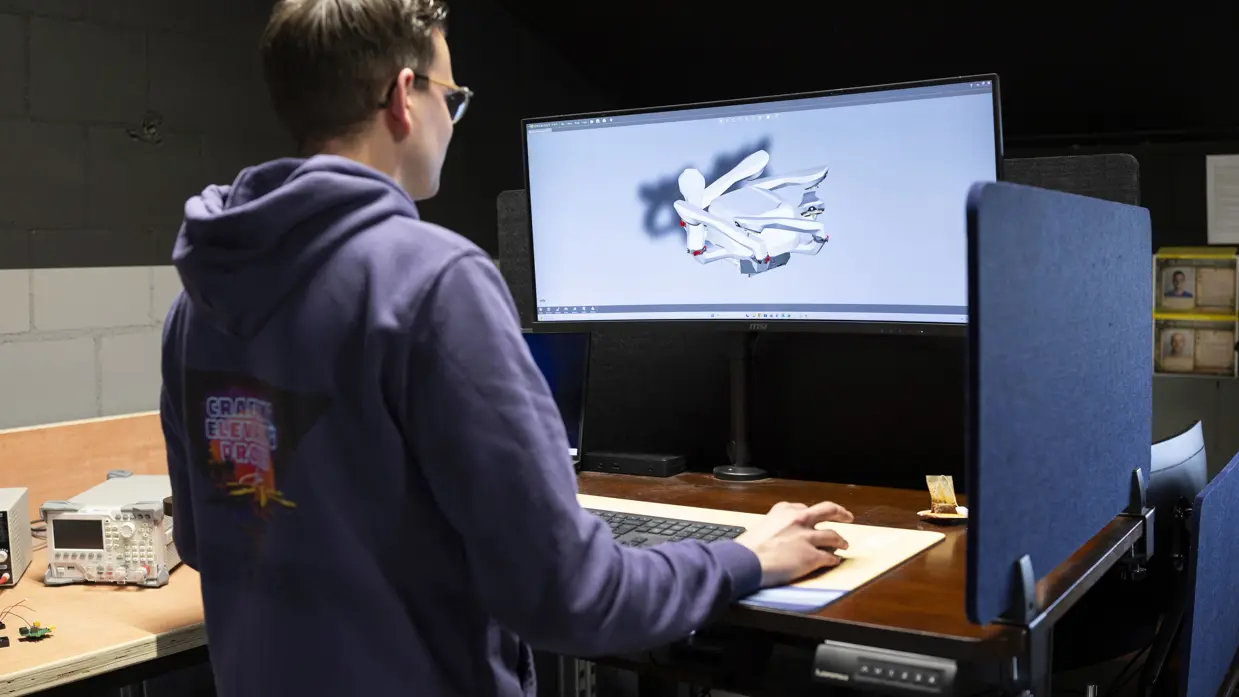Een medewerker van research en development kijkt naar een 3D-tekening op z’n scherm.