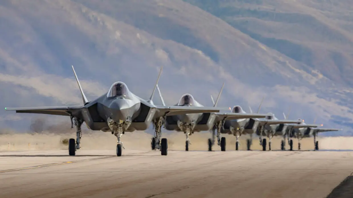 5 F-35's op een rij met op de achtergrond een berghelling.