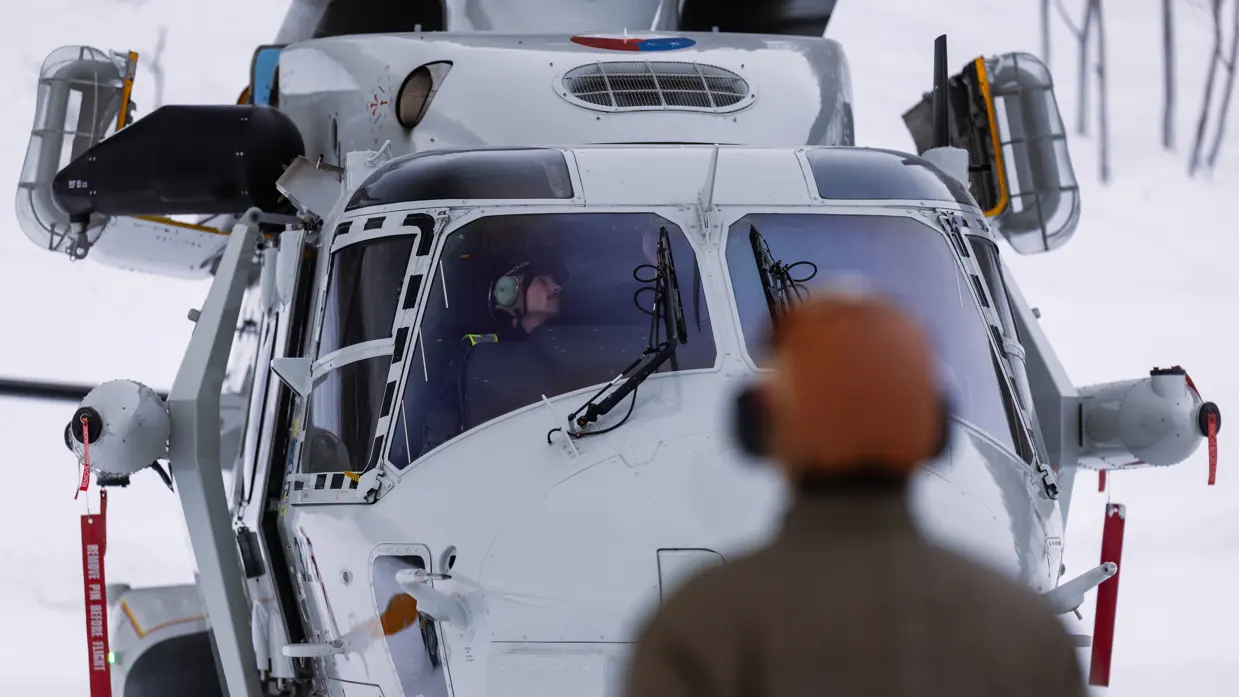 NH90 van het maritieme helikoptersquadron op een besneeuwd vliegveld in Noorwegen tijdens oefening Cold Response, met bemanningsleden zichtbaar in de cockpit.