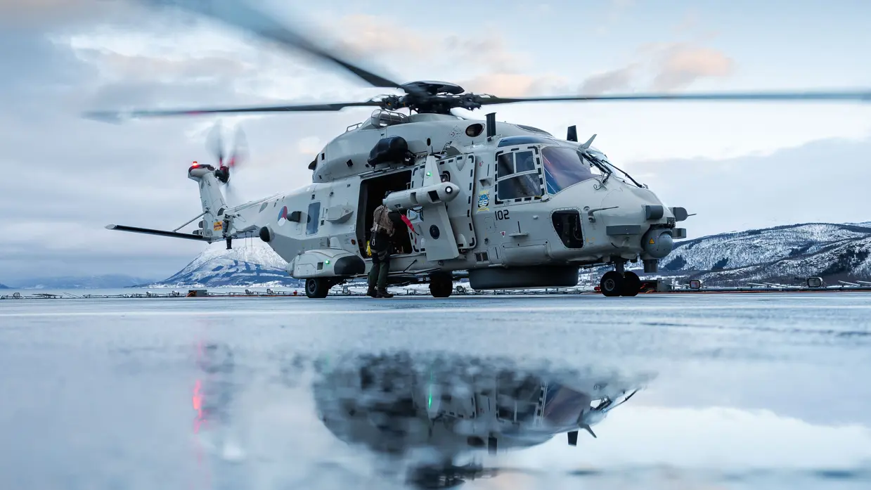 Een NH90 weerspiegelt in het smeltwater op het vliegdek van Zr.MS.Johan de Witt.