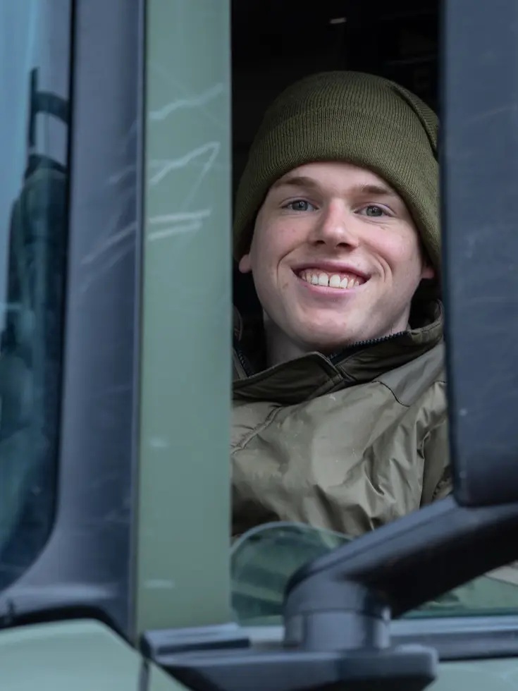 Een lachende soldaat in een vrachtwagen. 