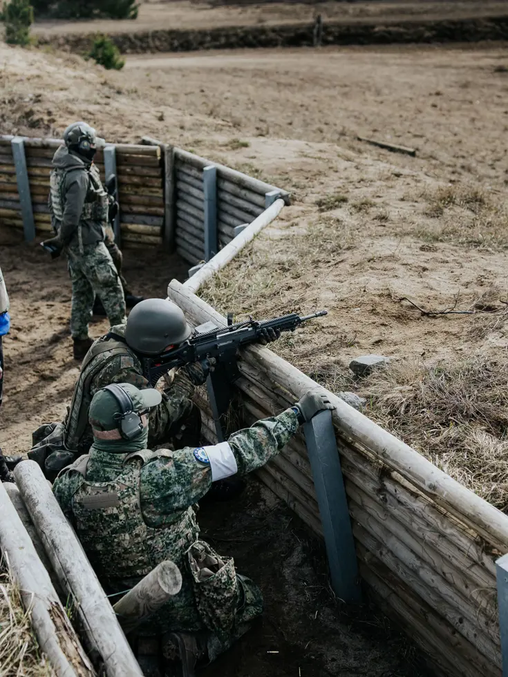 Oekraïners schieten vanuit loopgraaf, militair richt op klapschijven, Oekraïners liggen achter mitrailleur