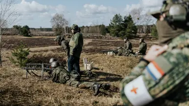 Militairen achter mitrailleur. 