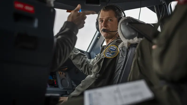 Een vlieger zit in de cockpit van de A330 MRTT en kijkt over zijn schouder achterom.